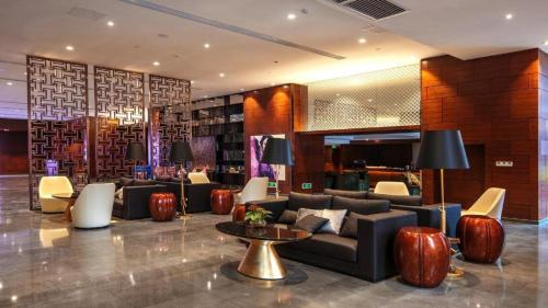 a lobby with a couch and chairs and a table at Yongzhou Chuang Fa Cheng XiaoXiangYi Hotel in Guzhuting