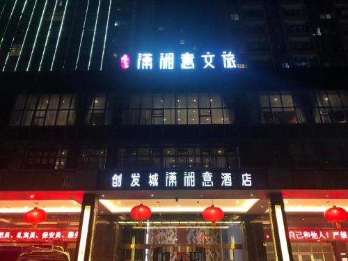 ein Gebäude mit einem Schild an der Seite in der Unterkunft Yongzhou Chuang Fa Cheng XiaoXiangYi Hotel in Guzhuting