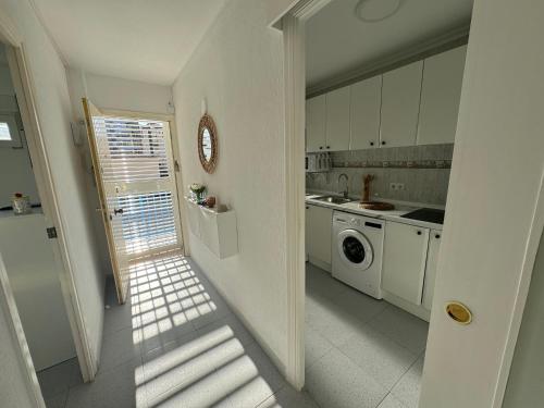a kitchen with white cabinets and a washer and dryer at Apartamento Muchavista Primera Línea de Playa By El Conserje in El Campello