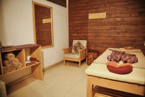 a room with a bed and a chair in a room at Khang Residency Thimphu in Thimphu