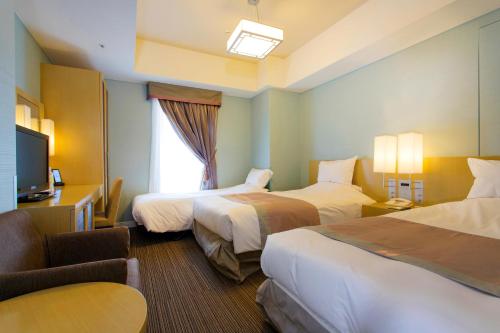 Habitación de hotel con 2 camas y TV en Hotel Monterey Hanzomon, en Tokio