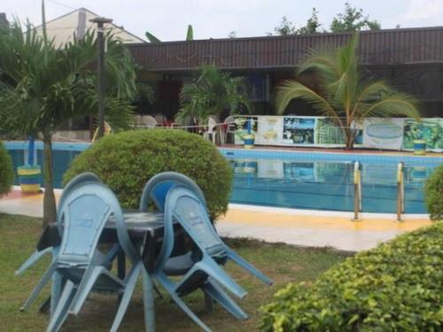 para składanych krzeseł obok basenu w obiekcie BEVALUABLE BANQUET AND GARDENS w mieście Alakohia