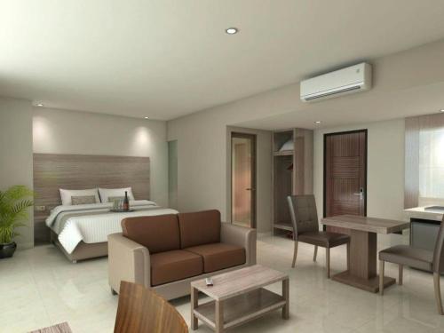 1 dormitorio con cama, sofá y mesa en Win Grand Hotel, en Kaliabang-tengah