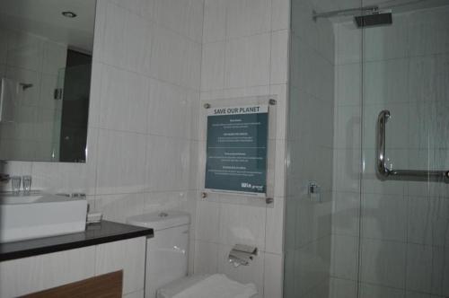 y baño con aseo, lavabo y ducha. en Win Grand Hotel, en Kaliabang-tengah