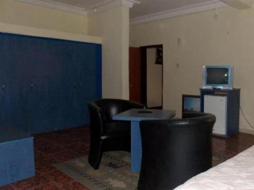 a room with two chairs and a table and a tv at ROYAL PARAGON HOTEL in Egbelu