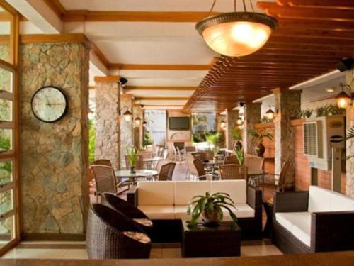 eine Lobby mit Stühlen und einer Uhr an der Wand in der Unterkunft Chocolate and Berries Hotel in Baliuag