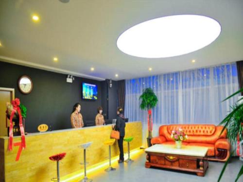 un groupe de personnes debout dans une pièce avec canapé dans l'établissement 7 Days Premium Shihezi Youxie Plaza Jun Ken Museum, à Shihezi