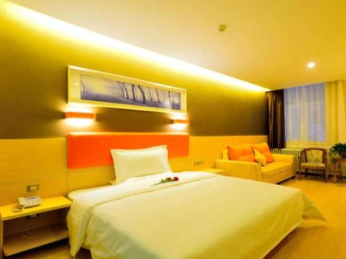 a hotel room with a large bed and a couch at 7 Days Premium Shihezi Youxie Plaza Jun Ken Museum in Shihezi