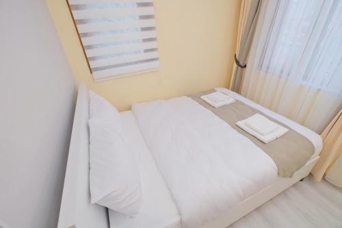 a white bed in a room with a window at Lucky Hotel İstanbul in Istanbul