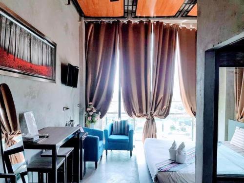 una sala de estar con escritorio y una habitación con ventana en Theloft boutique nakhonpanom, en Ban Noi Pho Kham