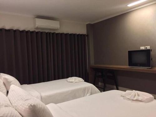 Habitación de hotel con 2 camas y TV de pantalla plana. en Kabinburi Sport Club - KBSC, en Ban Nong Kha