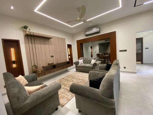 a living room with couches and chairs and a living room at Firefly Retreat-your home away from home in Rawalpindi