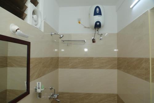 a bathroom with a mirror and a rocket on the wall at ANNAI RESIDENCY in Vellore