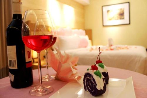 una botella de vino y un trozo de tarta y una copa de vino en BUMI SEGAH HOTEL en Tanjungredep