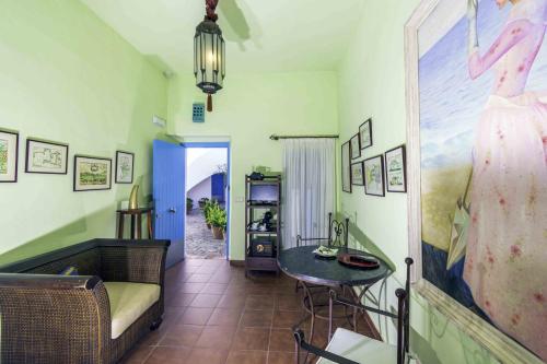 a living room with a table and a picture of a woman at Hotel Utopía in Benalup Casas Viejas