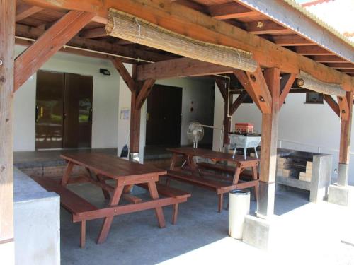 einen Pavillon mit Holztischen und Bänken in einem Zimmer in der Unterkunft Nature Miraikan in Kin