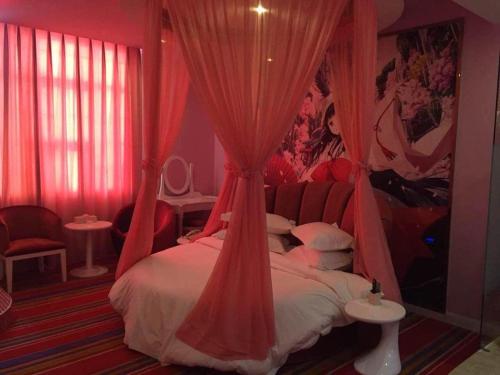 a bedroom with a bed with red drapes at TO915101 STILL LOVE THEME HOTEL in Chengdu