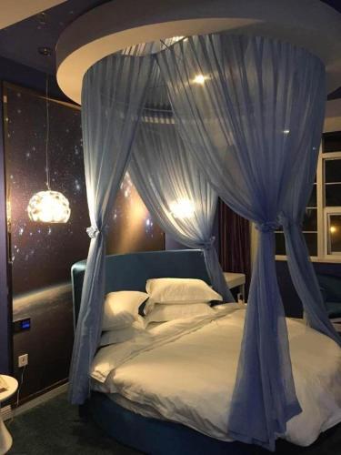 a bedroom with a bed with a blue canopy at TO915101 STILL LOVE THEME HOTEL in Sha-ho-p'u