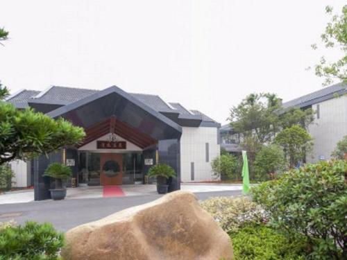 a building with a large rock in front of it at Tongxiang Inspirock Hotel in Jiaxing