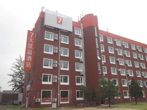 un grand bâtiment rouge avec des fenêtres blanches dans l'établissement 7 Days Premium Beijing Dabaotai Metro Station Luhua Road, à Pékin