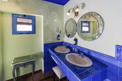 a blue and white bathroom with two sinks and mirrors at Hotel Utopía in Benalup Casas Viejas