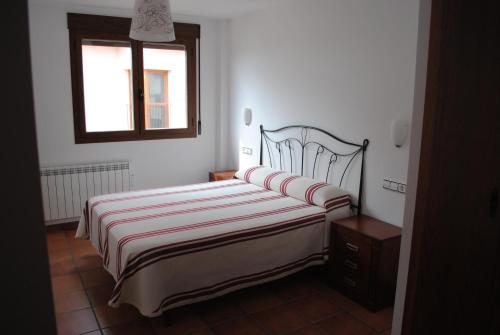 1 dormitorio con cama y ventana en Apartamentos Moravella, en Mora de Rubielos