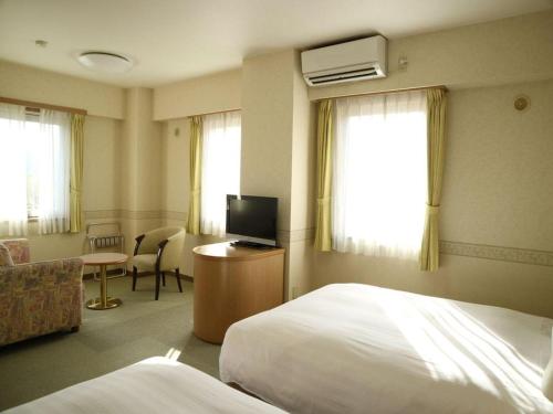 a hotel room with a bed and a television at KEIKYU EX INN Yokosuka Research Park in Kubiri