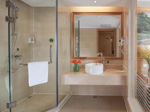 een badkamer met een wastafel en een douche bij Vienna Hotel Shenzhen Yantian Port Branch in Shenzhen