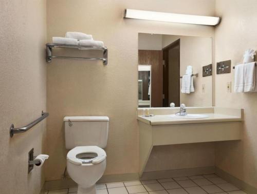 uma casa de banho com um WC, um lavatório e um espelho. em Hotel Flagstaff I-40 East Lucky Lane em East Flagstaff