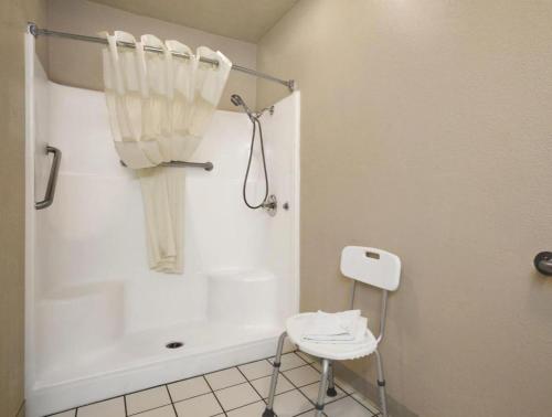 uma casa de banho branca com uma cadeira e uma banheira em Hotel Flagstaff I-40 East Lucky Lane em East Flagstaff