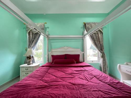 a bedroom with a bed with a pink bedspread and a window at Royal Maharani Bedugul in Tabanan