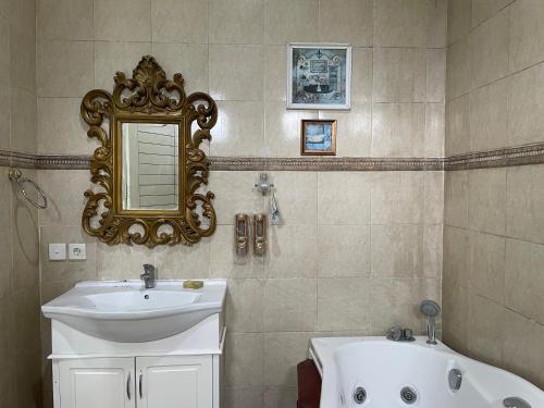 a bathroom with a sink and a mirror and a tub at Royal Maharani Bedugul in Tabanan