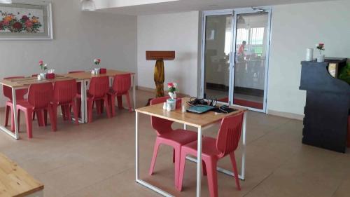 un comedor con sillas rojas y mesas en una habitación en Karimun City Hotel, en Tanjung Balai Karimun