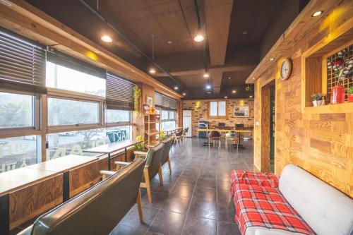un restaurante con bancos, mesas y ventanas en B&F Hotel en Yeosu