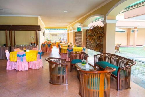 Hotel Griya Tirta في بانغكال بينانغ: مطعم فيه طاولات وكراسي في الغرفة