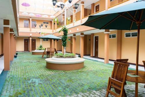 une cour avec des chaises et une fontaine dans un bâtiment dans l'établissement Hotel Griya Tirta, à Pangkal Pinang