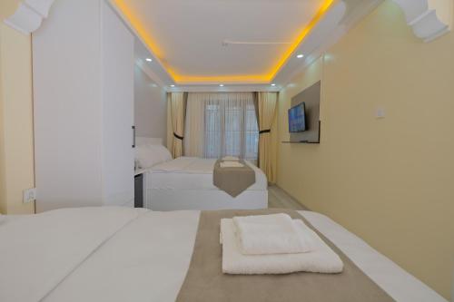 a bedroom with two white beds and a window at Lucky Hotel İstanbul in Istanbul