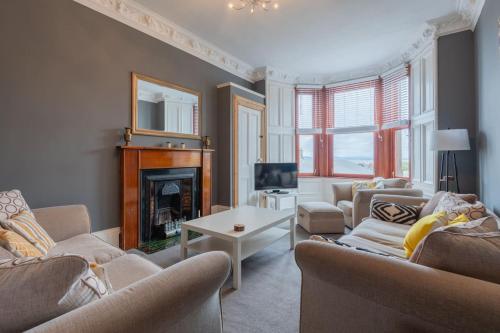 a living room with two couches and a fireplace at Bridge View Apartments in Dundee