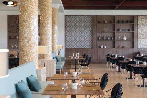EXCELLENCE PUNTA CANA - ALL INCLUSIVE - ADULTS ONLY في بونتا كانا: غرفة طعام مع طاولات وكراسي في مطعم