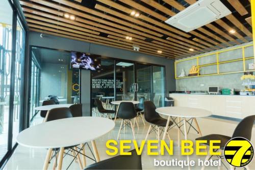 a dining room with tables and chairs and a tv at Seven bee boutique hotel in Surin