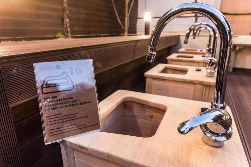 a sink in a kitchen with a sign on it at Kobos Hotel in Bucheon