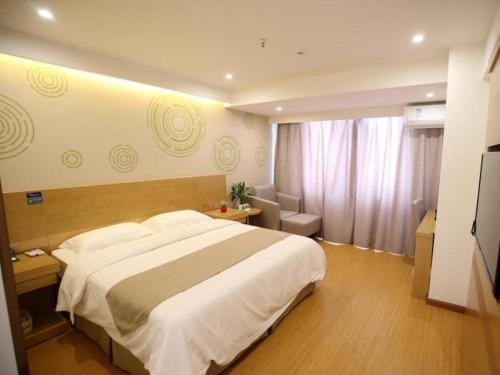 GreenTree Inn Xuancheng Jingxian Wannan First Street Express Hotel tesisinde bir odada yatak veya yataklar