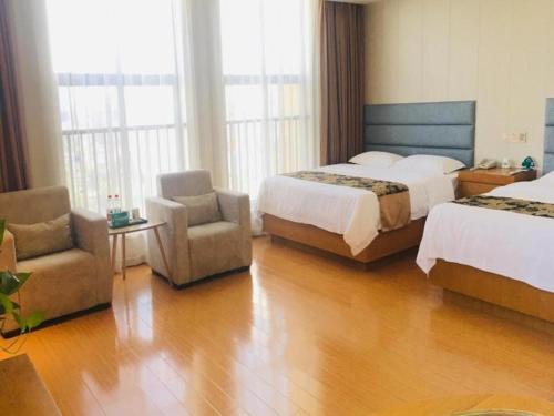 a hotel room with two beds and a chair at GreenTree Inn Yancheng Tinghu Area Wengang Road New Fourth Army Memorial Hotel in Yancheng