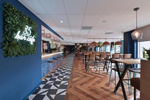 un ristorante con bar, tavoli e sedie di Travelodge Birmingham Airport a Sheldon