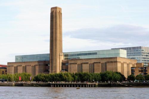 un grand bâtiment avec une tour en face d'une rivière dans l'établissement Travelodge London Central City Road, à Londres