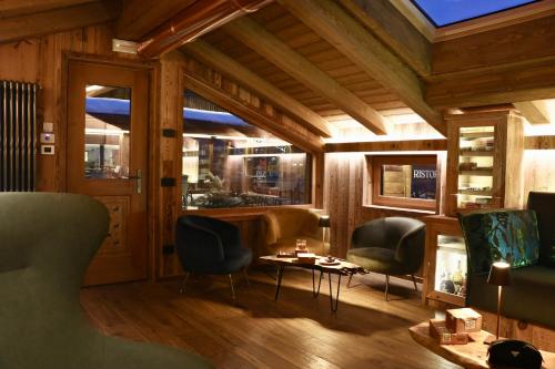 a room with two chairs and a table and windows at Hotel Galli's - Centro in Livigno