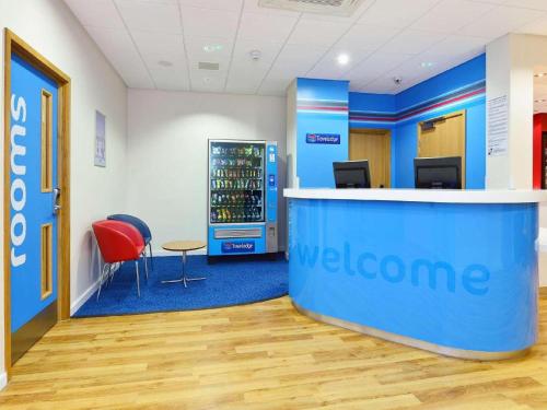 an office with a welcome counter and a red chair at Travelodge Glasgow Queen Street in Glasgow