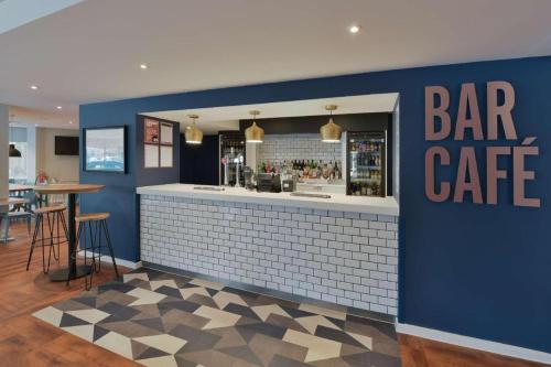 a bar with a blue wall and a bar cafe at Travelodge London Hounslow in Hounslow