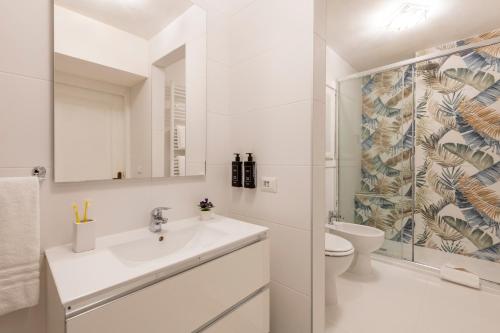 a white bathroom with a sink and a toilet at Milan Royal Suites - Centro in Milan