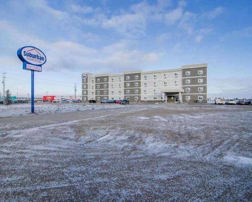a large building with a sign in front of it at Quality Inn and Suites - KindersLey in Kindersley